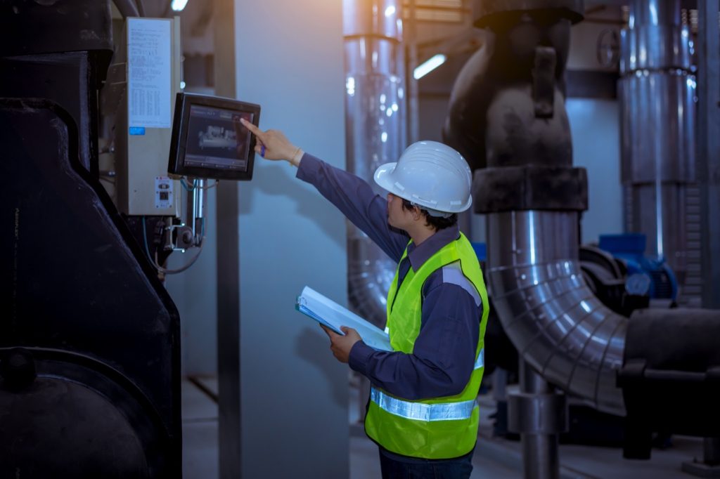 Técnico a monitorizar equipamentos de uma instalação industrial